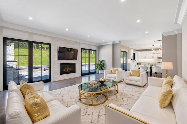 living room with a large fireplace, wood finished floors, and recessed lighting