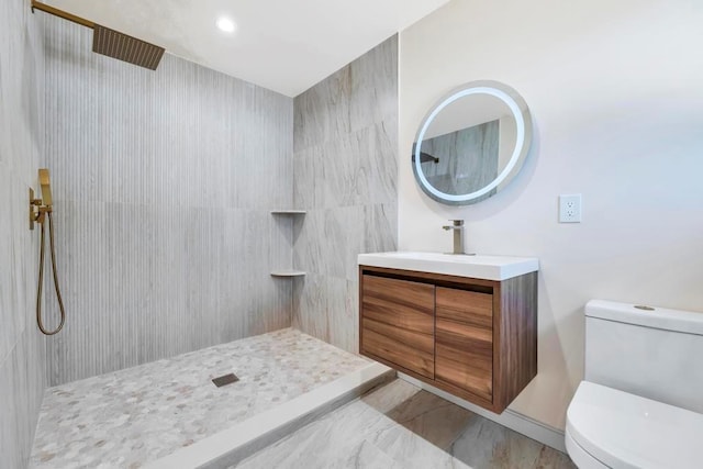 bathroom featuring vanity, a tile shower, toilet, and recessed lighting