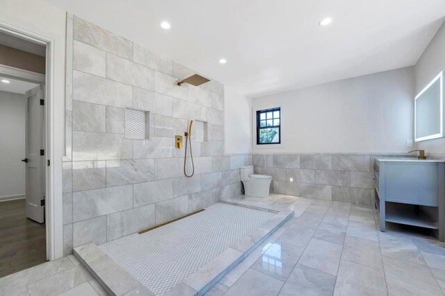 bathroom featuring a walk in shower, recessed lighting, vanity, tile walls, and tile patterned floors