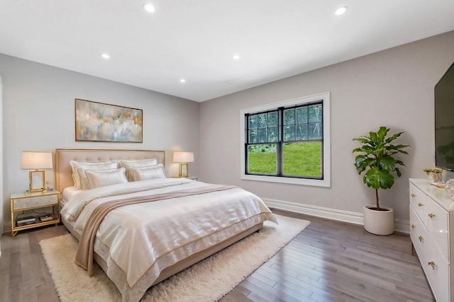 bedroom with light wood-type flooring, baseboards, and recessed lighting