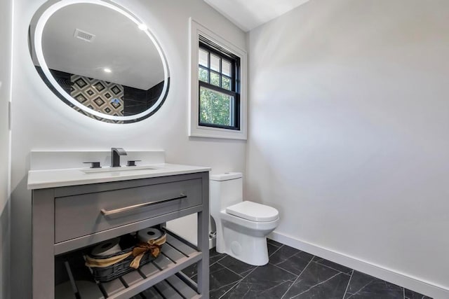 bathroom featuring baseboards, visible vents, vanity, and toilet