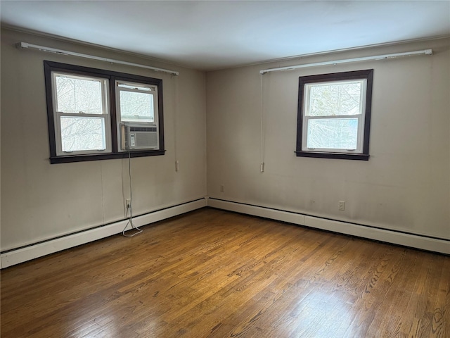 empty room featuring cooling unit and wood finished floors