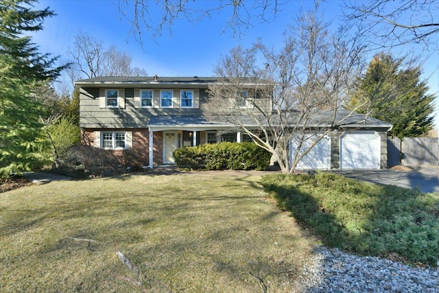 traditional home with driveway, an attached garage, fence, a front lawn, and brick siding