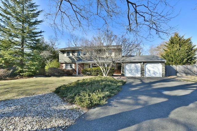 view of front facade featuring aphalt driveway, brick siding, fence, a garage, and a front lawn