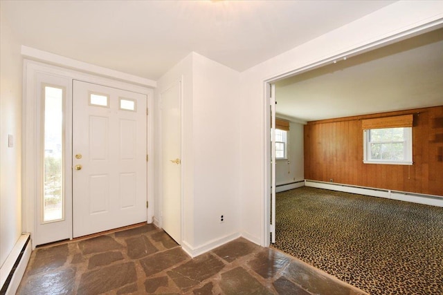 foyer entrance featuring wood walls, a baseboard radiator, a baseboard heating unit, and baseboards