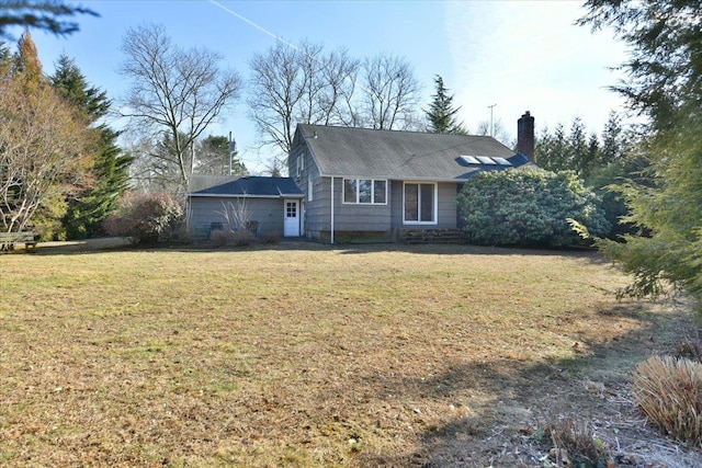 view of front of home featuring a chimney and a front lawn