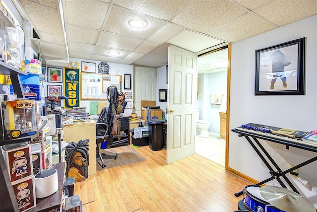 office area with a paneled ceiling, baseboards, and wood finished floors