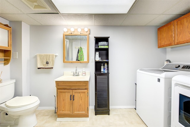 clothes washing area featuring a sink, laundry area, light tile patterned flooring, and washing machine and dryer