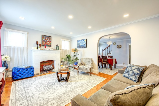 living room featuring arched walkways, ornamental molding, plenty of natural light, and a fireplace