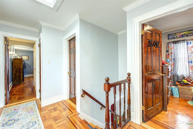 hall with a skylight, baseboards, arched walkways, crown molding, and an upstairs landing