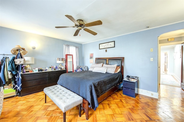 bedroom featuring arched walkways, ceiling fan, crown molding, and baseboards