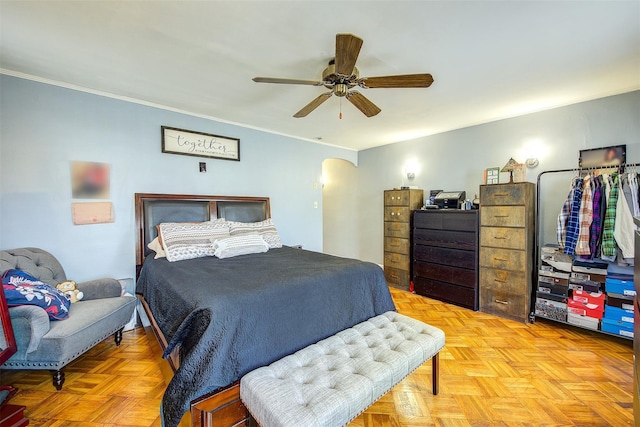 bedroom with arched walkways, ceiling fan, and ornamental molding