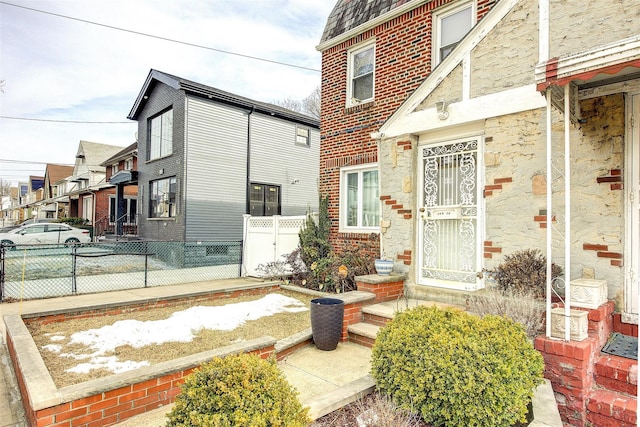 entrance to property featuring brick siding and fence