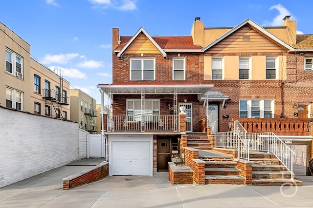 multi unit property featuring concrete driveway, brick siding, and an attached garage