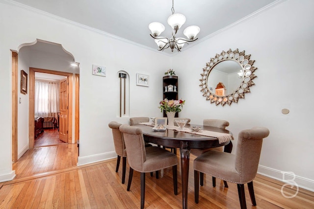 dining area featuring ornamental molding, light wood-type flooring, a notable chandelier, and baseboards