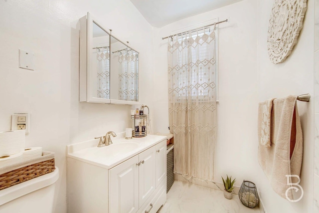 bathroom with toilet, marble finish floor, and vanity