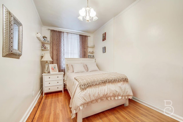 bedroom featuring light wood-type flooring, a notable chandelier, baseboards, and crown molding