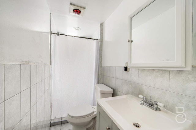 bathroom featuring toilet, curtained shower, tile walls, and vanity