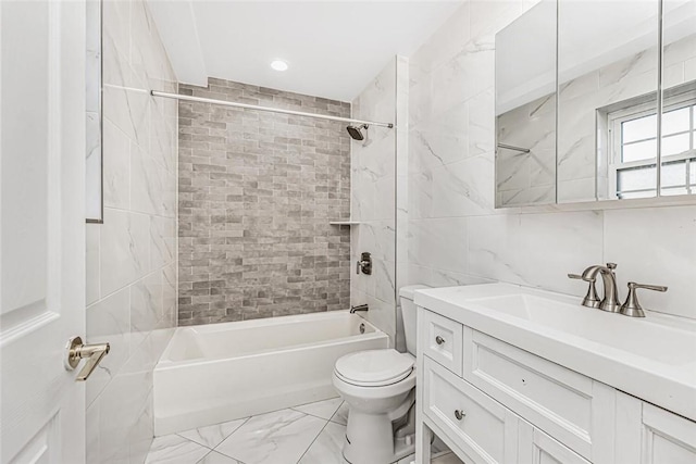 bathroom featuring marble finish floor, tile walls, toilet, vanity, and  shower combination