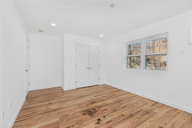 unfurnished bedroom with baseboards, recessed lighting, and light wood-style floors