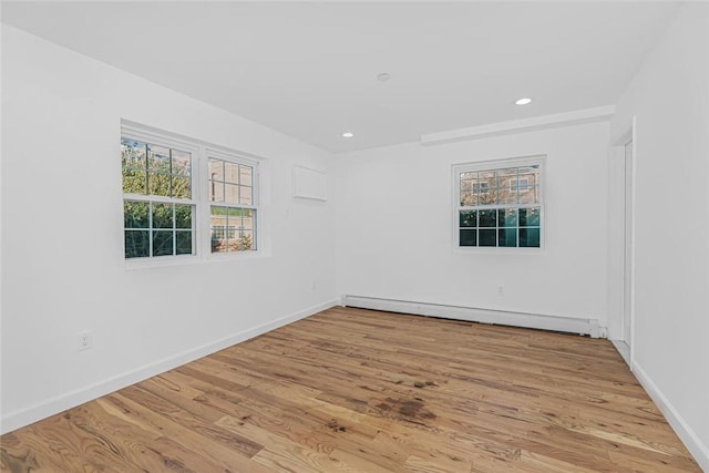 spare room featuring a baseboard radiator, light wood-style flooring, baseboards, and recessed lighting