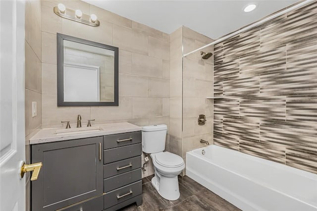 full bath with shower / bath combination, toilet, tile walls, and vanity