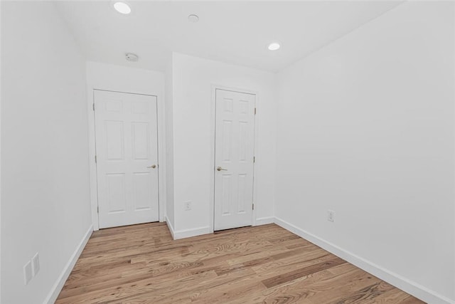 unfurnished bedroom featuring recessed lighting, light wood-style flooring, and baseboards