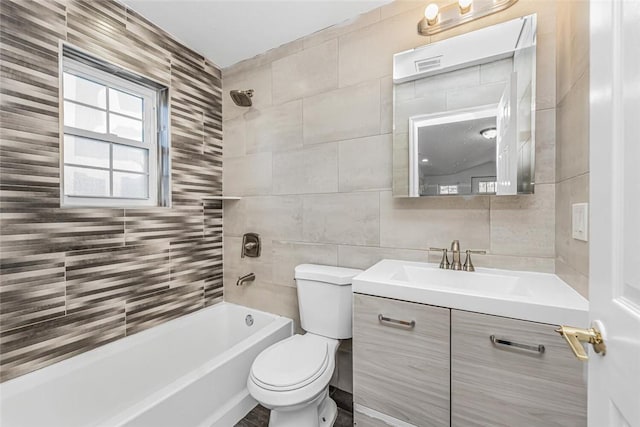 full bathroom with  shower combination, tile walls, toilet, and vanity