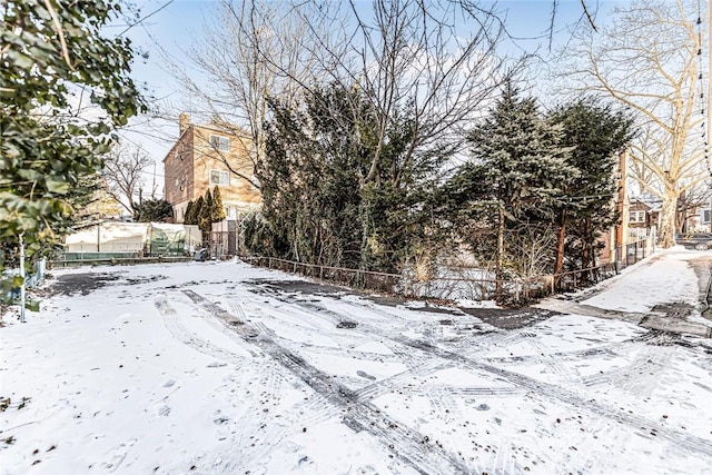 yard covered in snow featuring fence