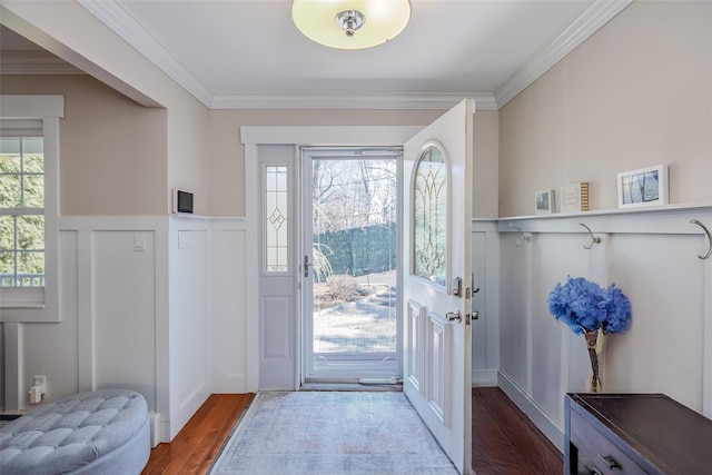 entryway with a healthy amount of sunlight, ornamental molding, and wood finished floors