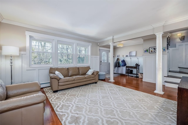 living area with decorative columns, ornamental molding, baseboard heating, and wood finished floors