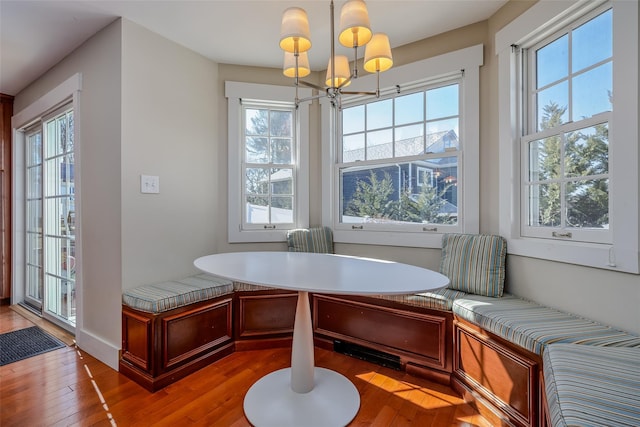 dining room featuring breakfast area, wood-type flooring, and a chandelier