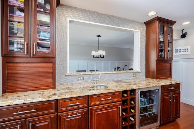 bar featuring beverage cooler, wood finished floors, a sink, tasteful backsplash, and decorative light fixtures