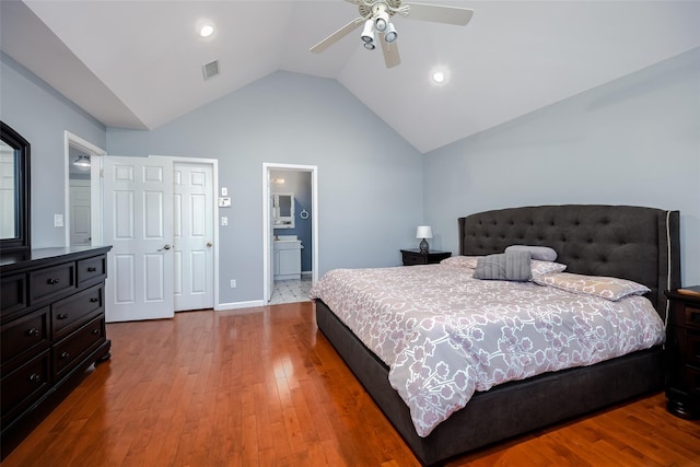 bedroom with light wood-type flooring, visible vents, vaulted ceiling, and a ceiling fan