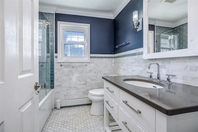 full bath with toilet, vanity, tile walls, baseboard heating, and crown molding