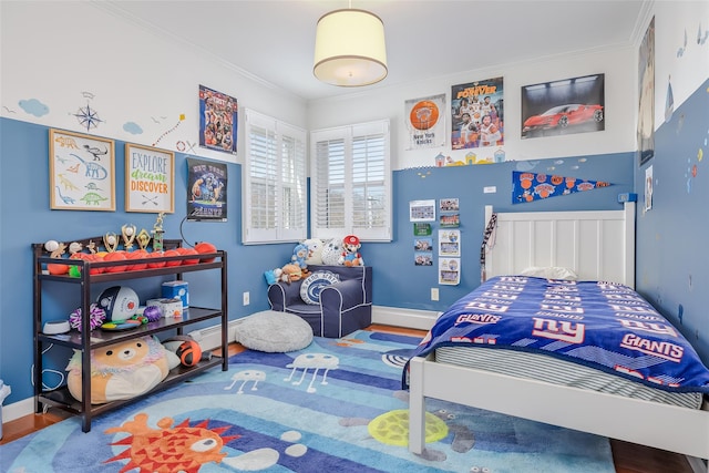 bedroom featuring ornamental molding, baseboards, and wood finished floors