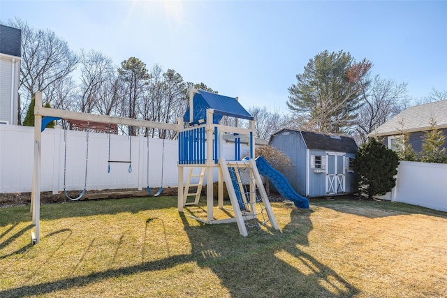 view of playground featuring a yard, a storage unit, an outdoor structure, and a fenced backyard