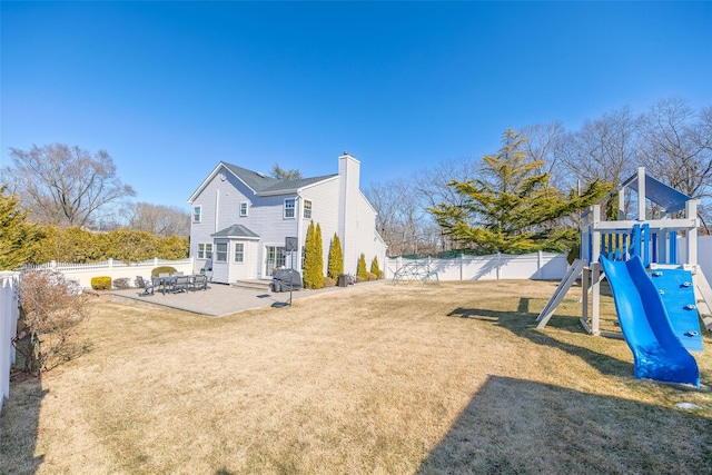 rear view of house with a patio, a lawn, a playground, and a fenced backyard