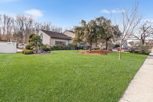 exterior space with fence, a chimney, and a front lawn