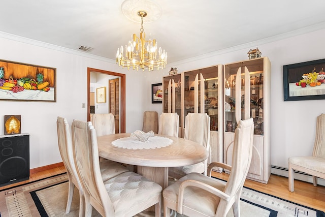 dining space with light wood finished floors, a notable chandelier, visible vents, and crown molding