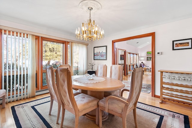 dining space with a chandelier, crown molding, and light wood finished floors