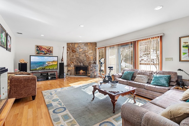 living area with light wood-type flooring, a fireplace, and recessed lighting