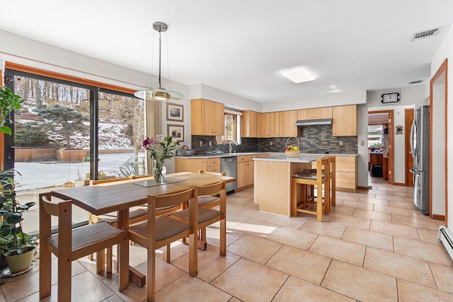 kitchen with tasteful backsplash, visible vents, appliances with stainless steel finishes, under cabinet range hood, and light brown cabinets