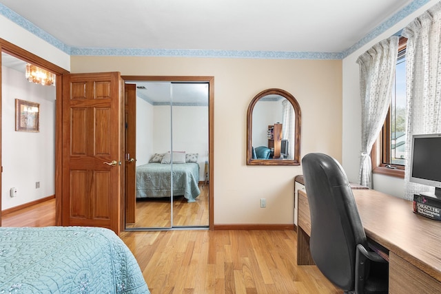 bedroom featuring a closet, light wood-style flooring, and baseboards