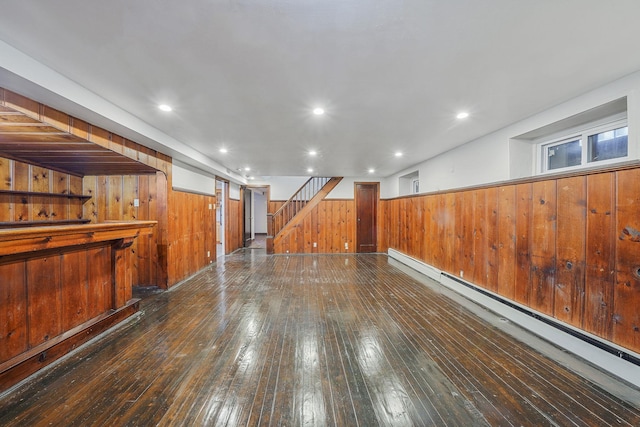 182-37 Radnor Rd, Jamaica Estates, NY 11432 - finished basement with dark wood-style floors, recessed lighting, a baseboard heating unit, wooden walls, and stairs