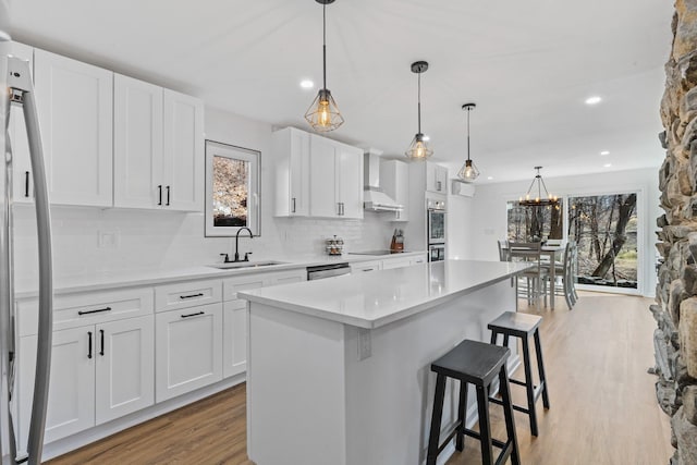 kitchen featuring a sink, light wood-style floors, appliances with stainless steel finishes, and a wealth of natural light