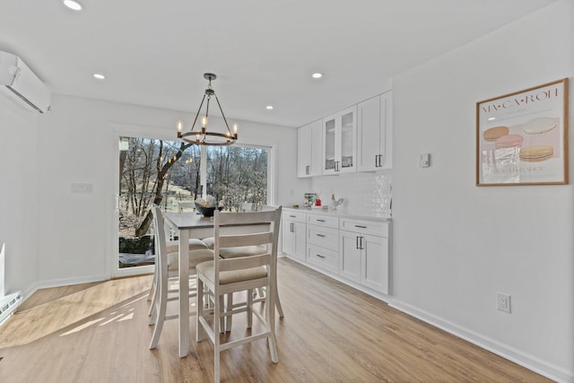 dining area with recessed lighting, baseboards, light wood-style floors, and an AC wall unit