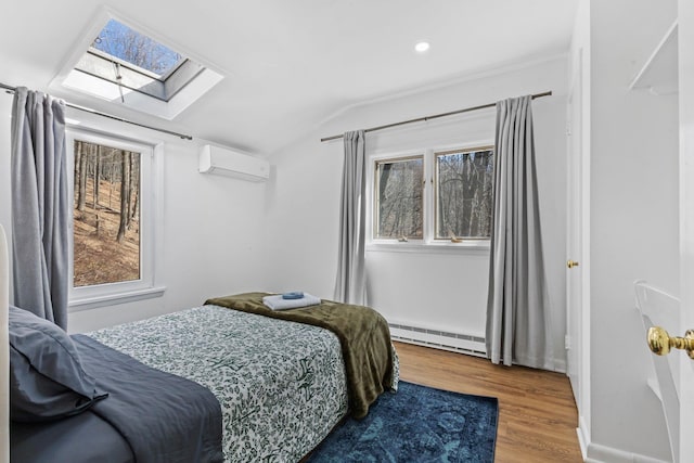 bedroom featuring wood finished floors, baseboards, a baseboard radiator, an AC wall unit, and lofted ceiling with skylight