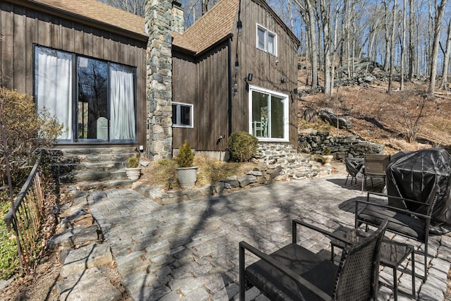 view of patio with a grill, entry steps, and outdoor dining area