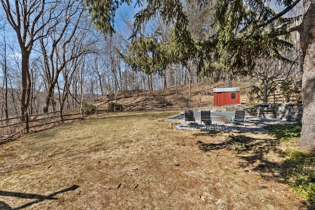 view of yard with a patio area, fence, an outdoor structure, and a shed